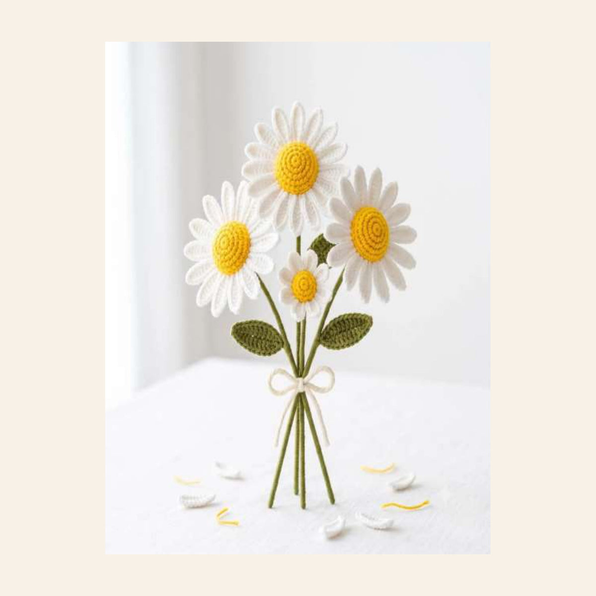 Crochet white daisy bouquet with yellow centres tied with a bow