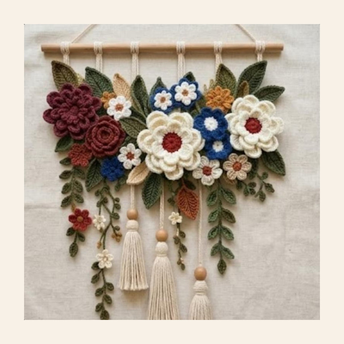 Crochet floral wall hanging with cream and maroon flowers and three tassels