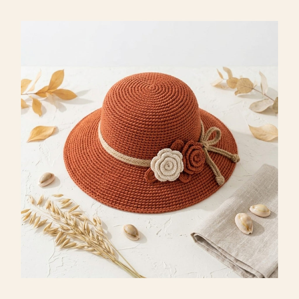 Flat lay of the terracotta crochet bucket hat with its flower trim