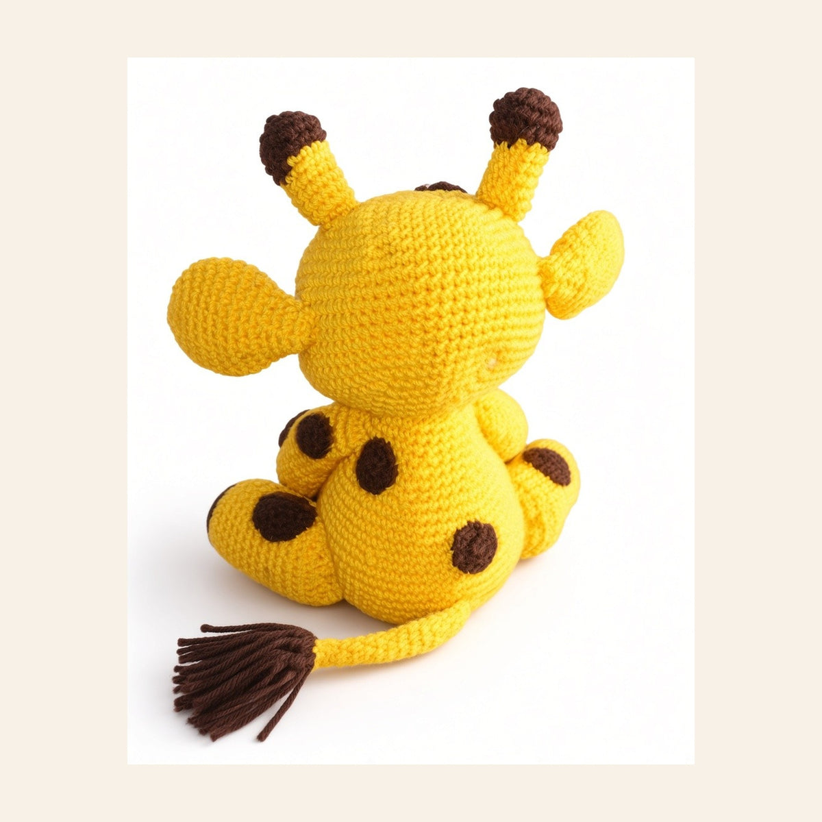 Back view of the crochet giraffe showing the tufted tail