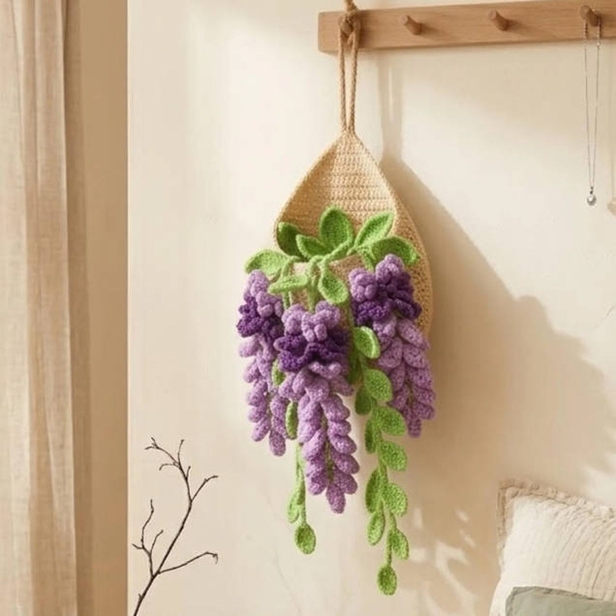 Crochet teardrop wall pot with trailing purple lavender hanging against a wall