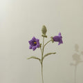 Crochet lily of the valley flower stem with deep purple bell flowers and green leaves