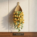 Crochet teardrop wall pot filled with yellow lily of the valley flowers and trailing leaves