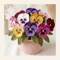 Crochet pansy flowers in purple and yellow in a pink crochet vase