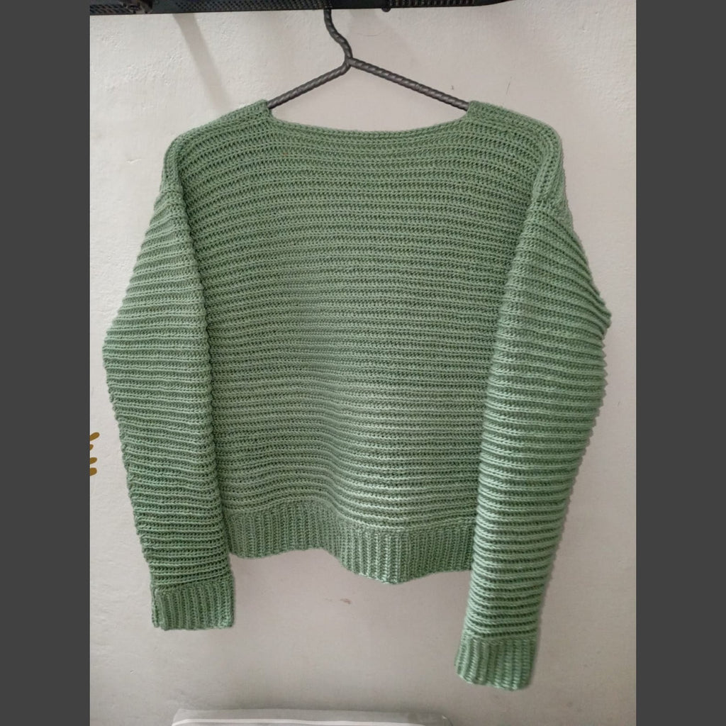 Back of the oversized green ribbed crochet cardigan showing the sleeves