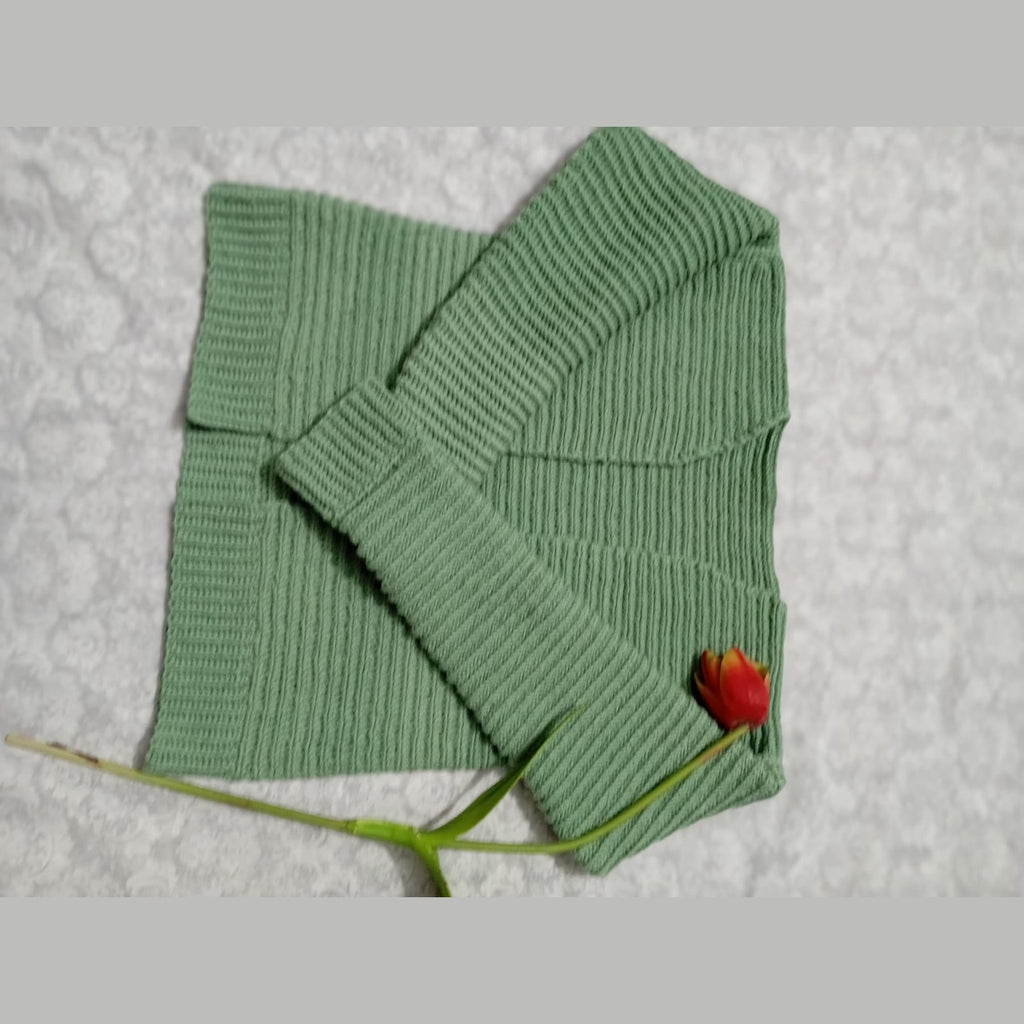 Green crochet rib stitch cardigan folded to show the ribbed sleeve and cuff