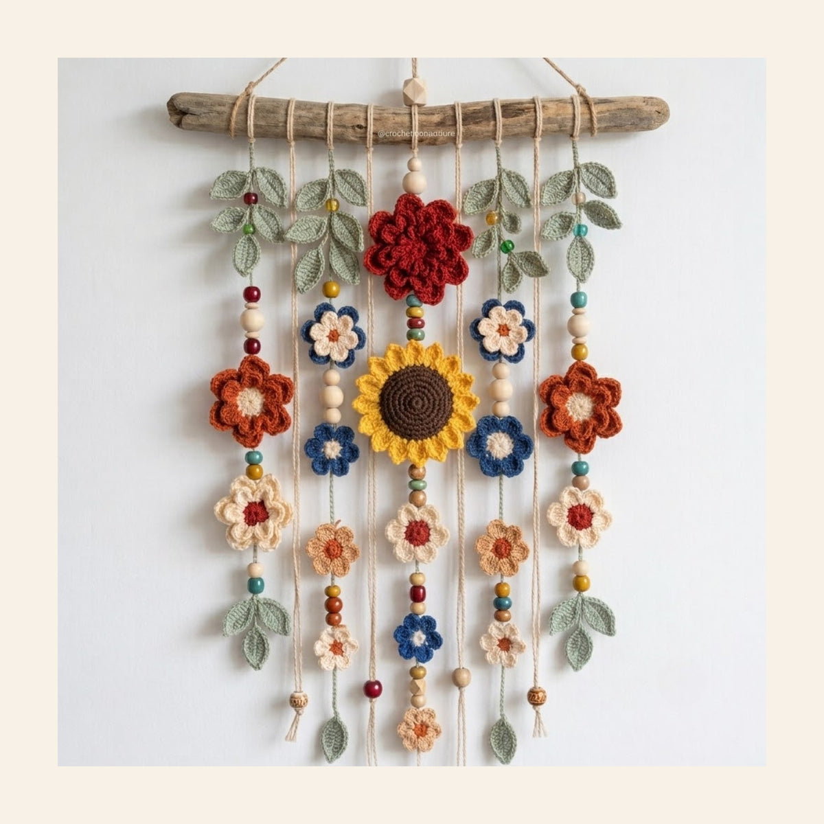 Crochet wall hanging with a central sunflower and beaded flower strands
