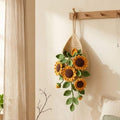 Crochet teardrop wall pot with yellow sunflowers and trailing green leaves