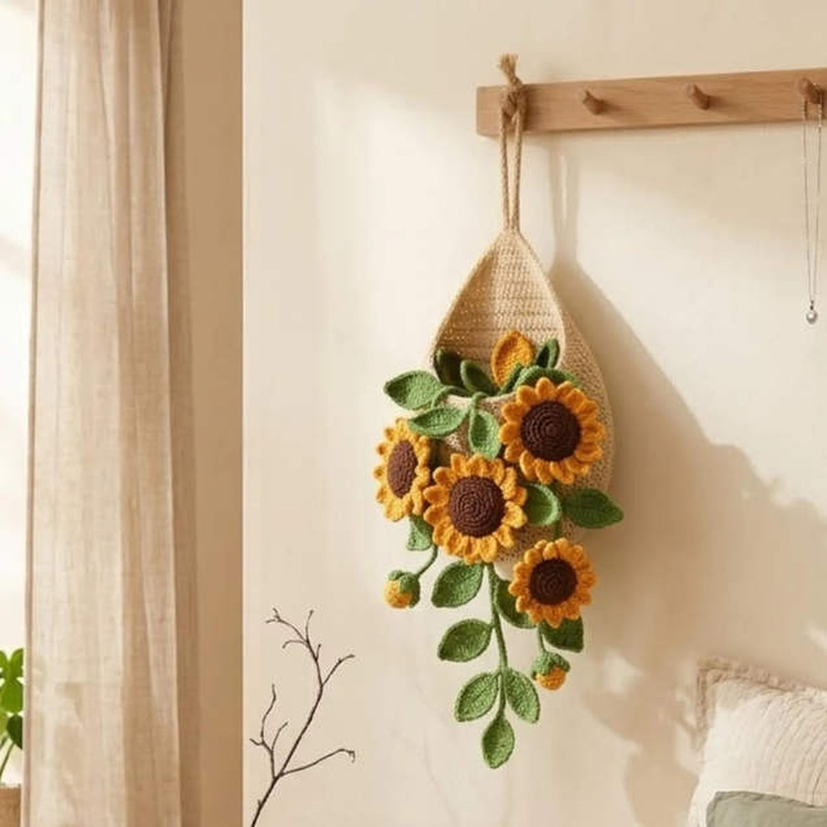 Crochet teardrop wall pot with yellow sunflowers and trailing green leaves
